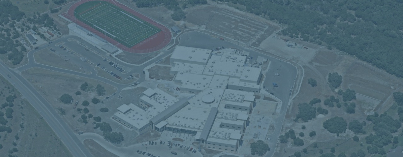 aerial view of large public school campus with buildings, parking lots and athletic fields