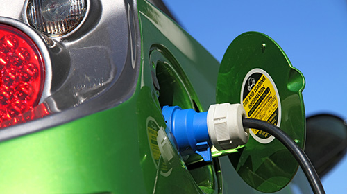 close-up of electric charging plug connected to electric vehicle socket