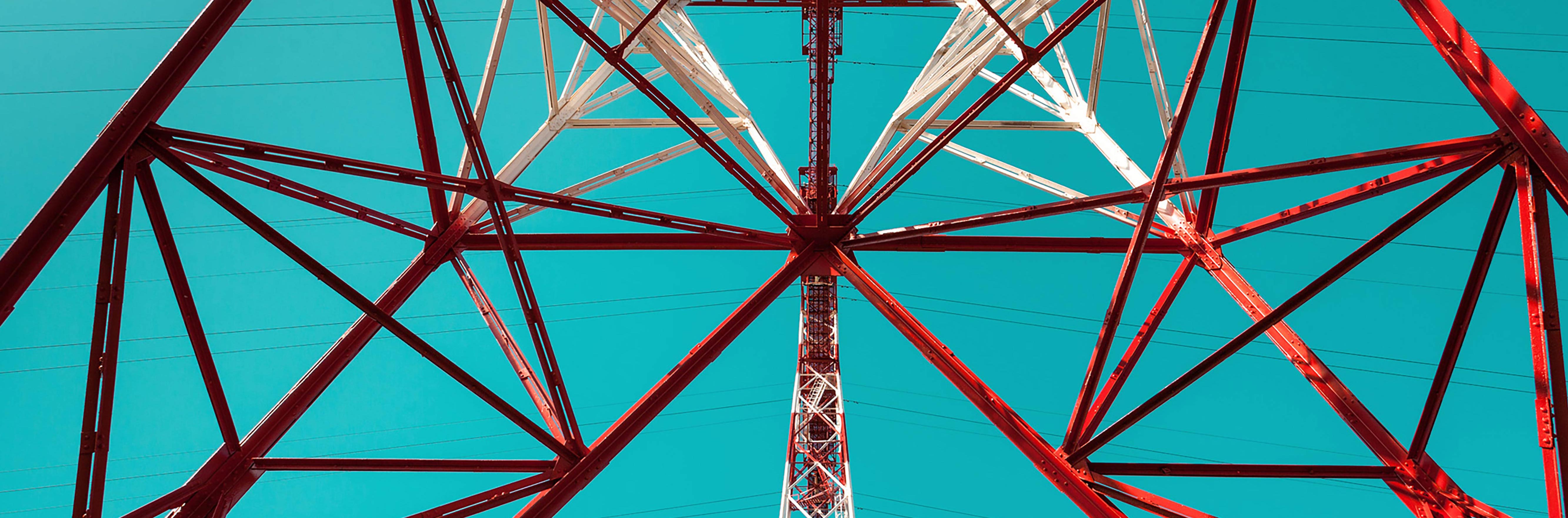 close-up of high voltage post transmission tower with blue sky background
